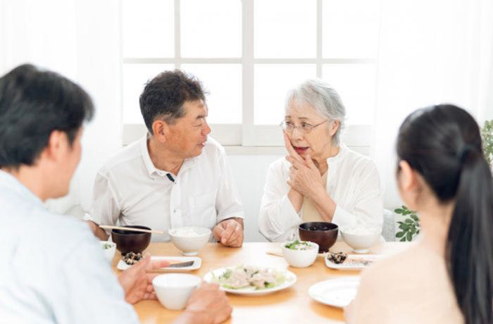 ご家族も一緒に!入れ歯やブリッジのケア 敬老の日に家族で食事をしながら高齢者の入れ歯やお口の状態を確認する様子