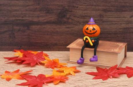 インフルエンザシーズンがやってきました ハロウィンのかぼちゃの人形と紅葉の落ち葉、秋の季節感を表す写真